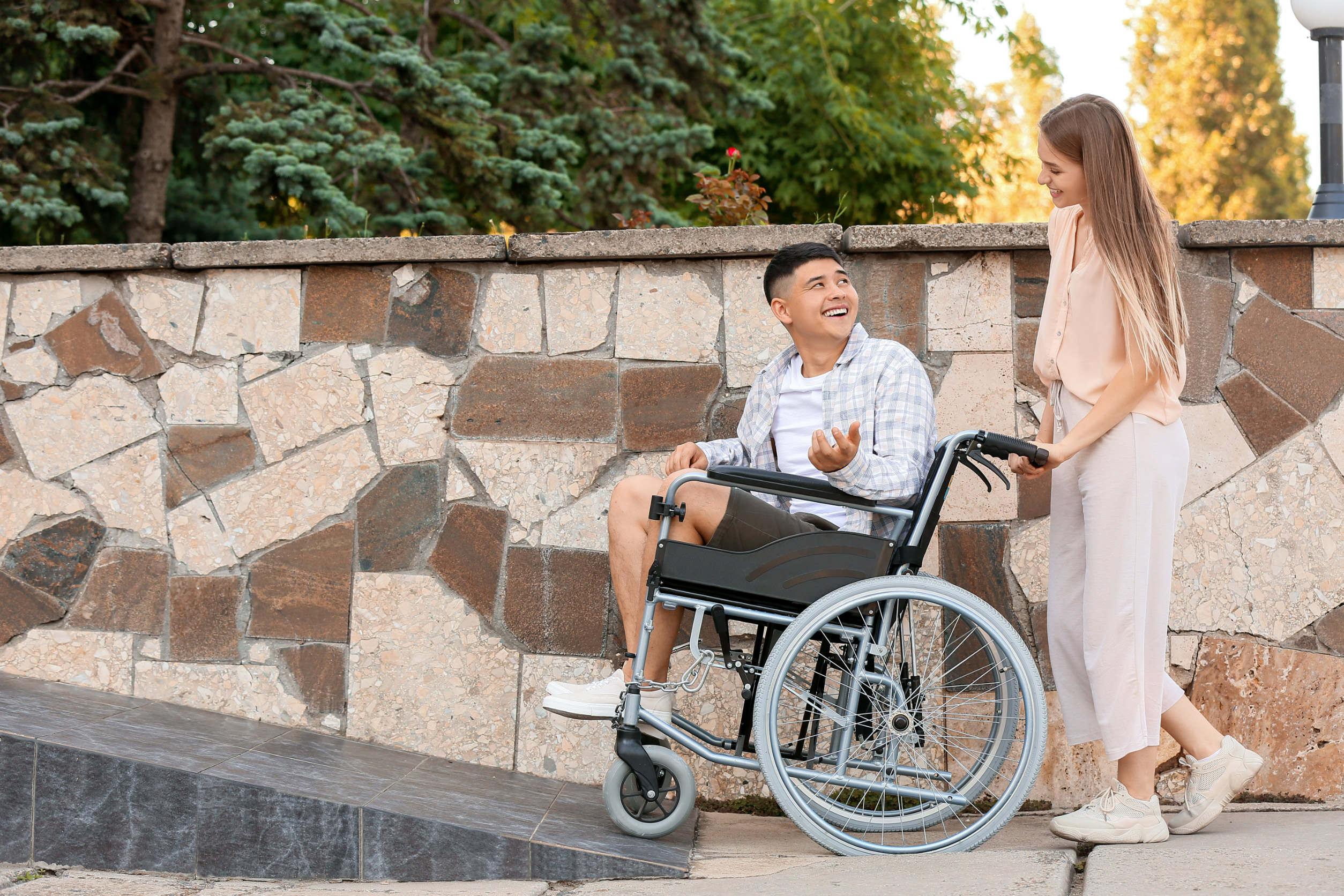 man pushed up wheelchair ramp